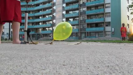 Popping a bunch of balloons outside of housing property for pure enjoyment during the day