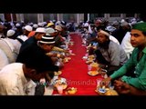 Muslim devotees eating food during Iftar at Nizamuddin Dargah