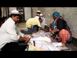 Muslim family arranging Iftar plates at Nizamuddin Dargah