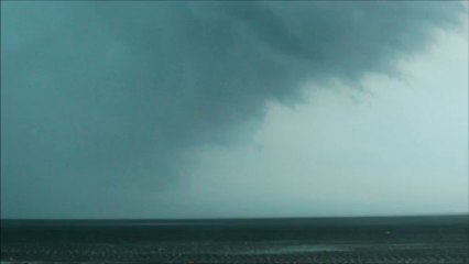 Un gros nuage gris poussé par un vent violent soulevant l’eau de la mer