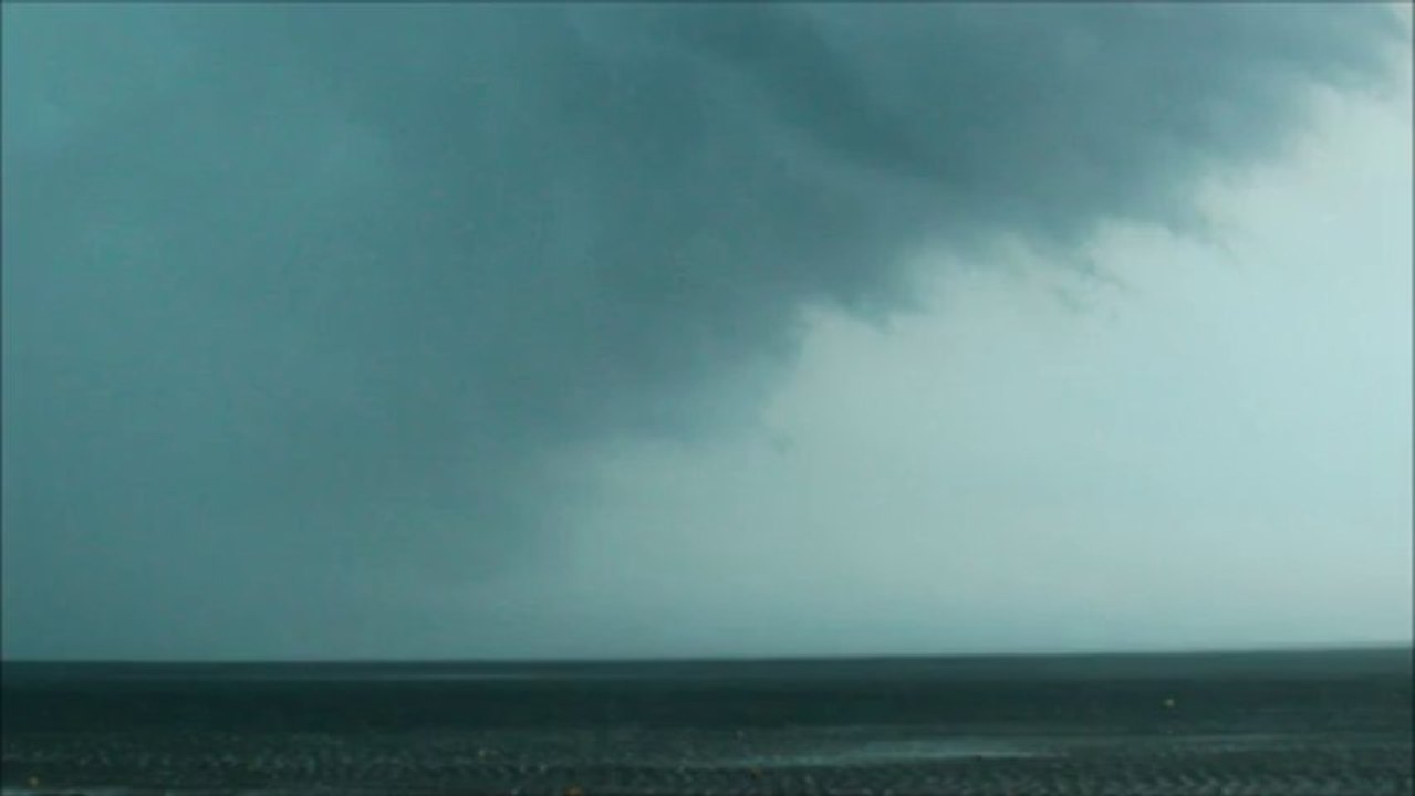 Un gros nuage gris poussé par un vent violent soulevant l’eau de la mer