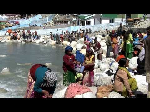 A Man dips in the cold water of Gangotri Dham as other devotees prepare for prayer