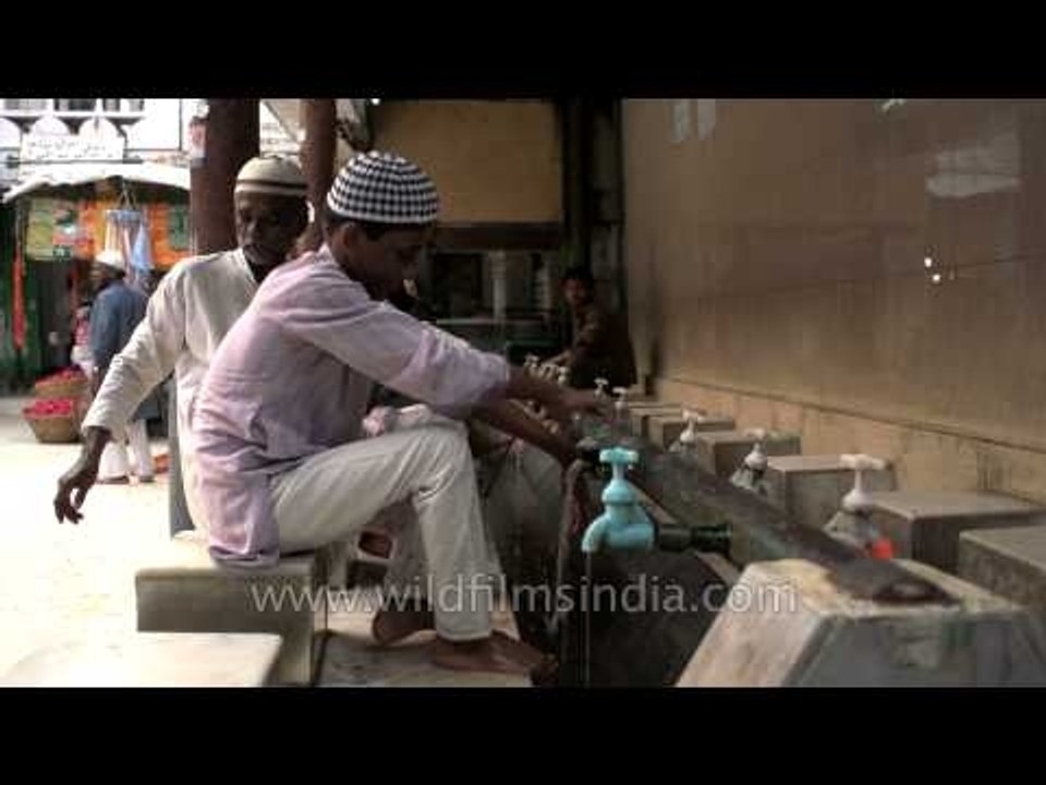 Muslim child performing Wuzu before prayer at holy shrine of Nizamuddin Dargah