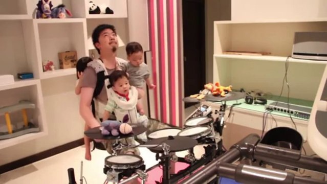 Jouer de la batterie à une main en portant trois bébés.. CHAPEAU L'ARTISTE!!