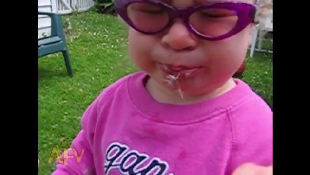 Une petite fille souffle sur un pissenlit et le met dans sa bouche... Adorable et trop marrant!