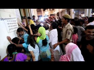 Devotees in que during Krishna Janmashtami