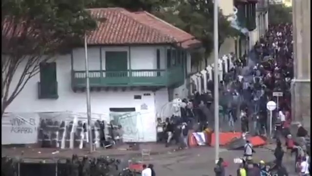 Femme vient aider des policiers à Bogota (Colombie)