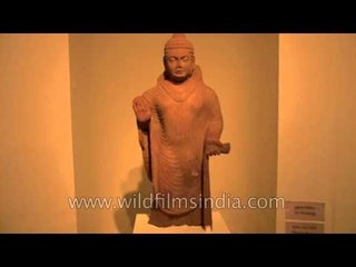 An artistic sandstone sculpture of standing Buddha in abbayamudra