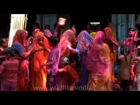 Women smeared in colours dancing during Holi celebration