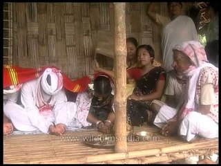 Elderly village woman praying for the newly wedded couple in Assam