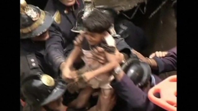 Rescuers pull survivors from a collapsed building