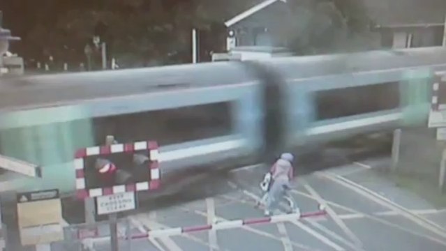 Cycliste frôle la mort devant un train