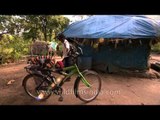 Youngest member of tree house family going to school on his bicycle