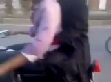 Young Guy Doing One Wheeling With His Girlfriend on Bike