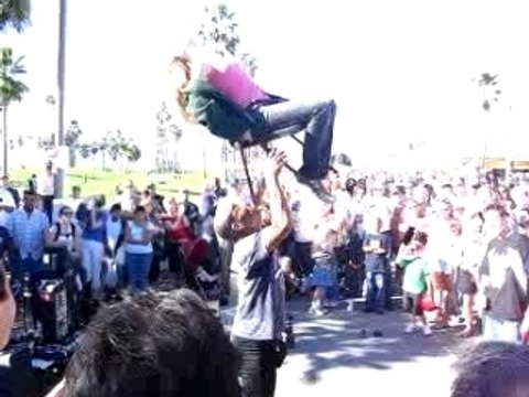 Guy lifts girl in chair w/ his mouth