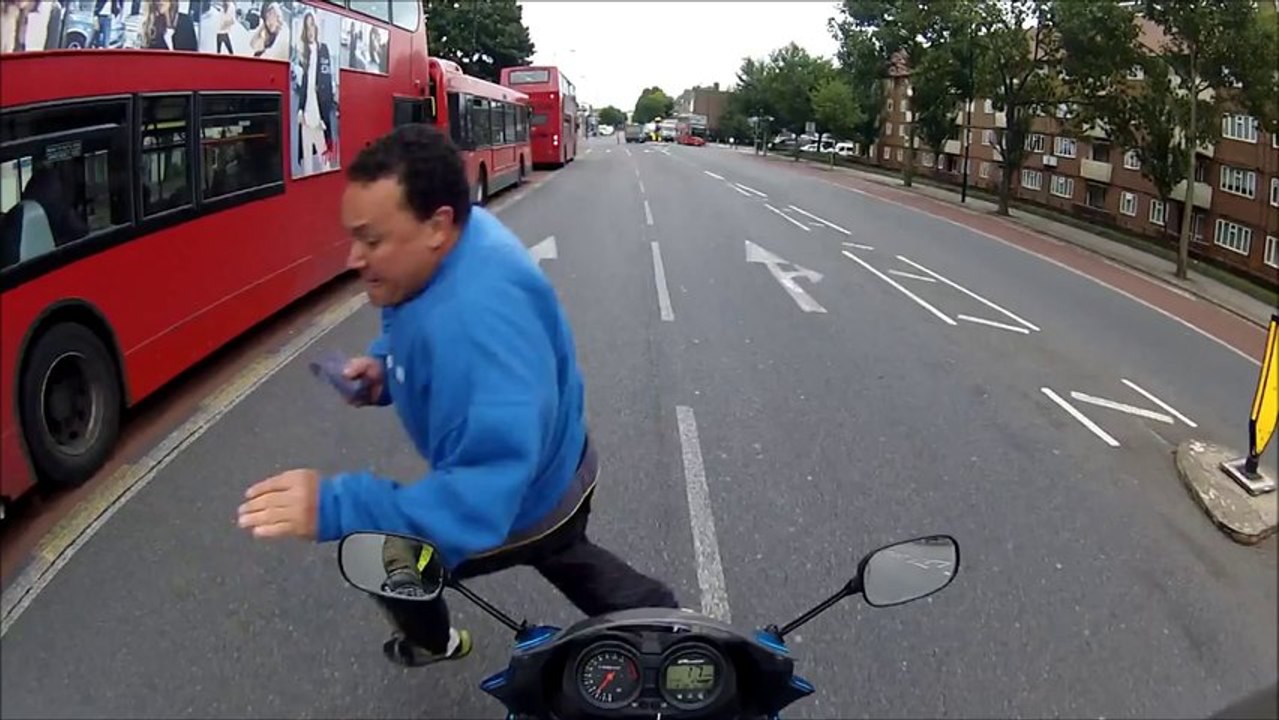 un piéton esquive sur un motard