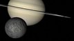 CU grey moon lower left orbits Saturn reverse rotation