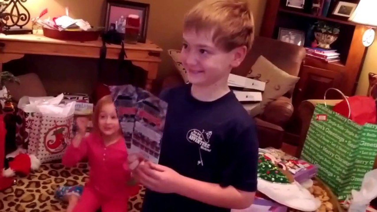 So happy kid opening his Christmas present : Auburn Football tickets