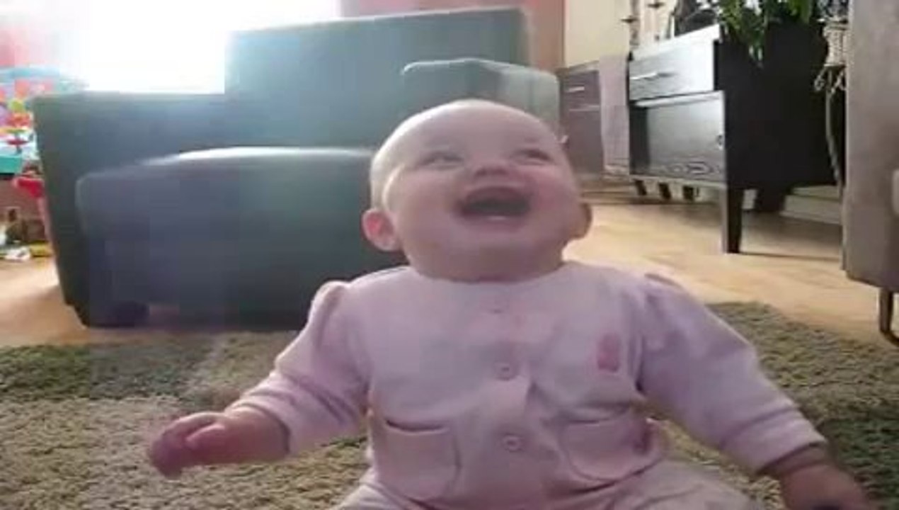 Bébé rigole en regardant le chien manger du popcorn