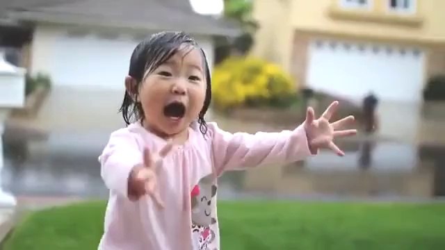 Questa bimba scopre per la prima volta la pioggia. Guardate la sua reazione