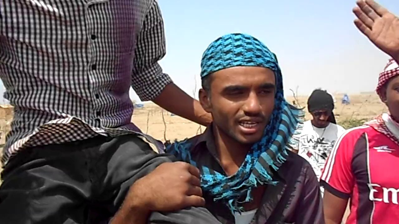 الشاب ابراهيم راجح حسين محمولا على الأكتاف ...بعد ان حطم المسلحون ساقيه.