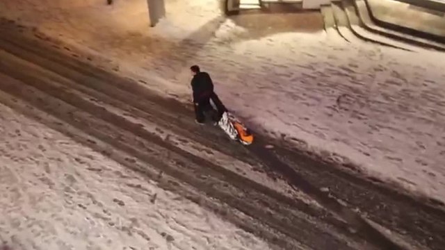 Des russes traînent leur pote ivre dans la neige