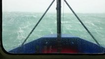 Un bateau passe des vagues de plus de 15 mètres de haut