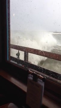 Une vague géante casse la vitre d'un restaurant en bord de mer