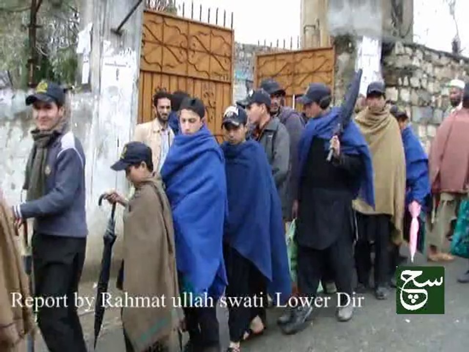 maidan students giving annual exam in rain under unbrellas