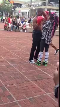 2 young dudes trade blows boxing at the Inner Harbor in Baltimore ends with a vicous knockout