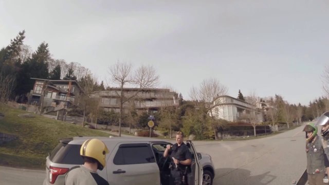 Un policier coupe la route à des longboardeurs