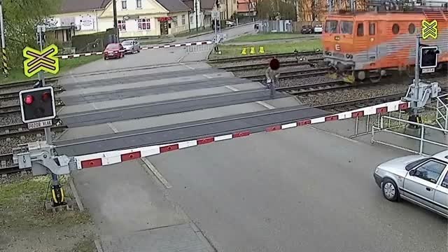 Un vieil homme traverse quand le train passe