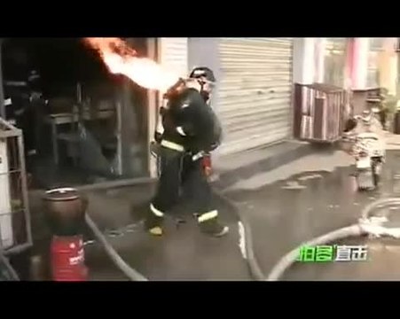 Un pompier chinois transporte une bouteille de gaz en feu