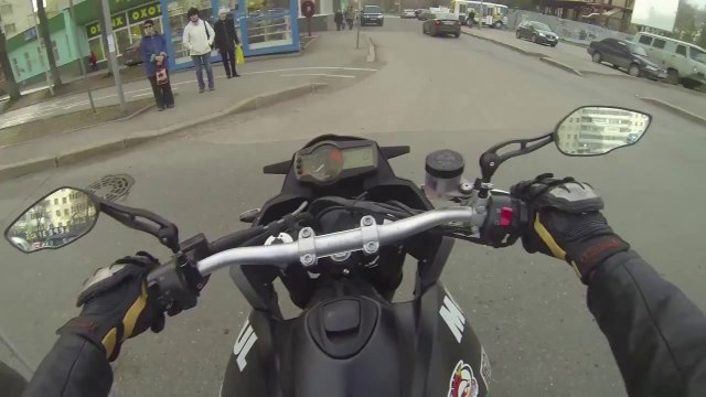 Un motard aide un vieil homme à traverser la route