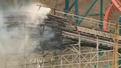 La montagne russe d'un parc d'attraction prend feu