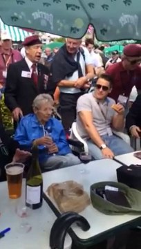 Un vétéran anglais chante au café de Gondrée à Bénouville