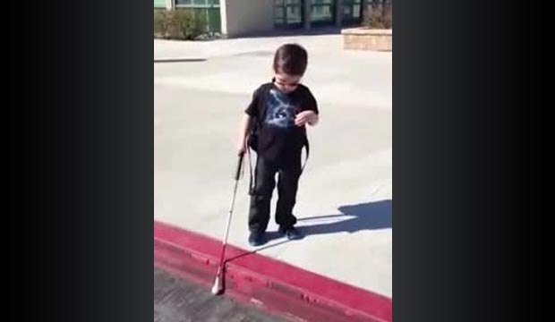 Un enfant aveugle descend un trottoir