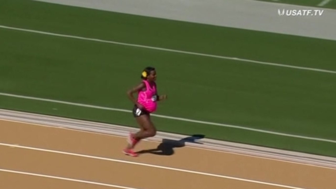 Pregnant runner defends title