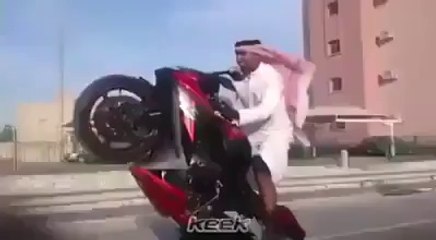 watch this Arabic man with one wheeling on bike.