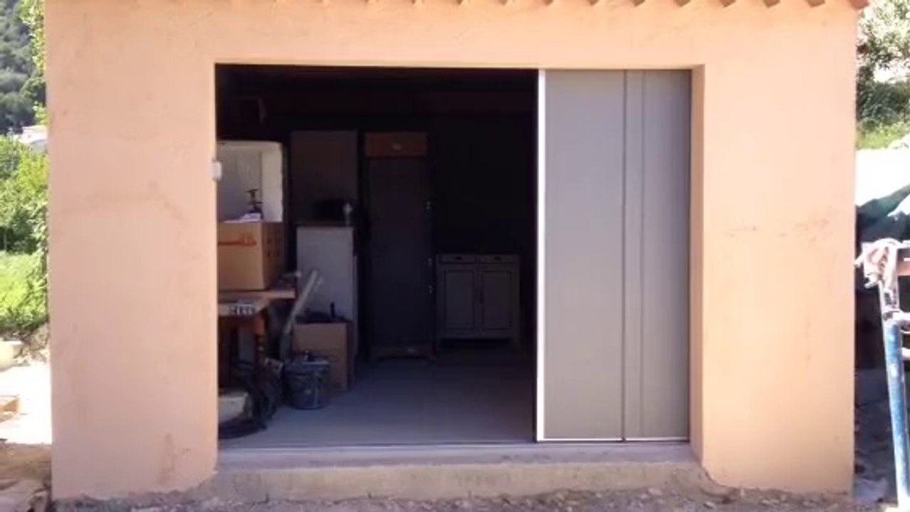 Porte de garage latérale motorisée installée par APG Accès Portes de Garage