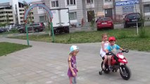 Un enfant drague les filles avec sa moto électrique