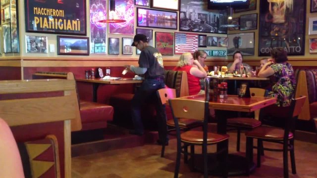 Serveur très énergique nettoie les tables d'un restaurant