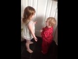 Baby siblings argue about laundry room dryer