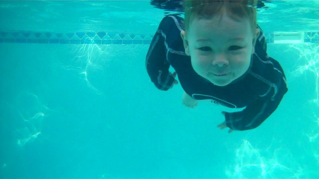 Talented baby jumps in and swims across pool