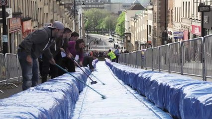 Artist turns central street into giant water slide