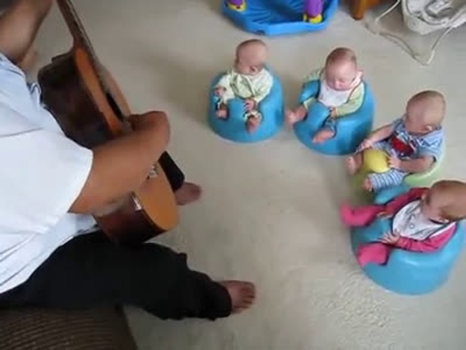 gitar eşliğinde şarkı söyleyen bebekler