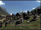 Tired Amarnath pilgrims take rest near camp in Kashmir