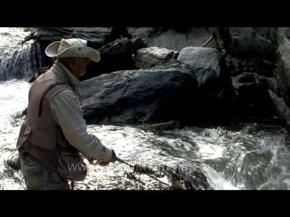An angler fishing on Jhelum river during angling expedition in Kashmir