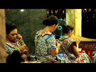 Erawan dancers punching away on their mobile phones, Thailand