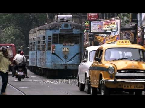 Yellow Hindustan Ambassador taxi cab and trams battle it out on Kolkata roads